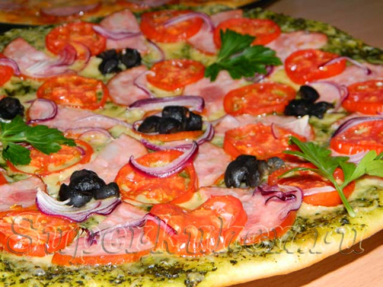 Пицца с соусом песто, ветчиной и маслинами